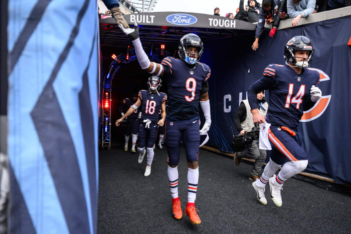 Jaquan Brisker puts his hand up to high five a fan as he walks down the tunnel onto the field